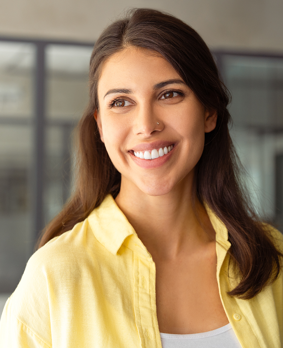 Smiling woman looking into mirror brushing her teeth smoothly